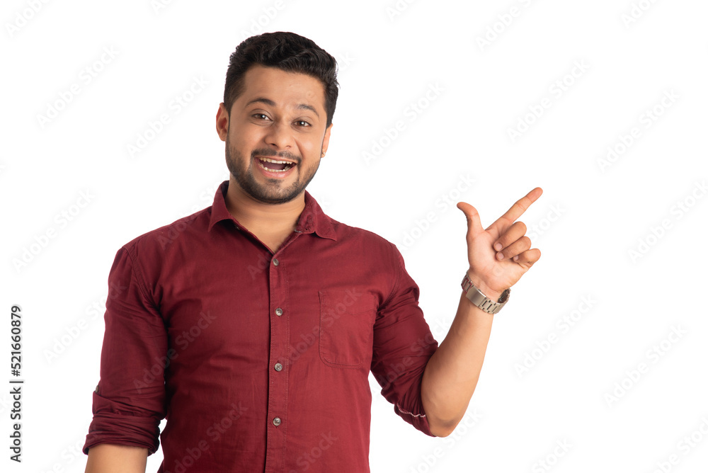 Portrait of a successful cheerful young man pointing and presenting something with hand or finger with a happy smiling face. Portrait of a successful cheerful young man pointing and presenting something with hand or finger with a happy smiling face.
