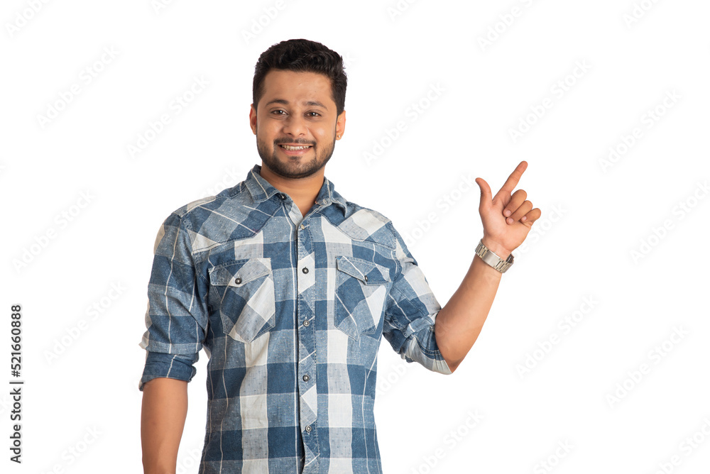 Portrait of a successful cheerful young man pointing and presenting something with hand or finger with a happy smiling face. Portrait of a successful cheerful young man pointing and presenting something with hand or finger with a happy smiling face.