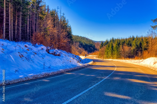 View over landscape covered with snow during sunny winter day.