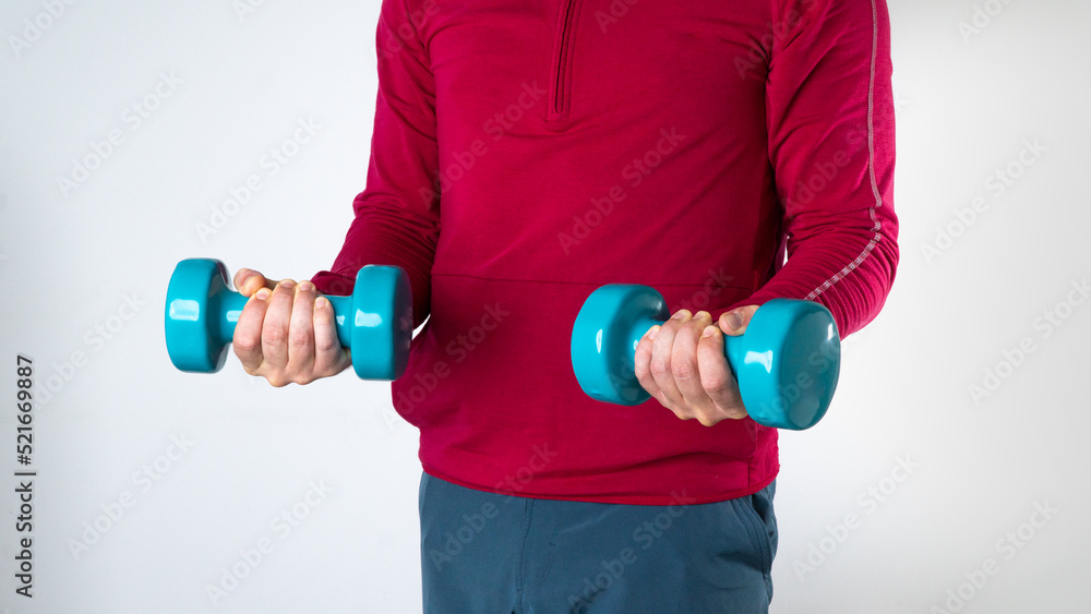 A man in a sports fom holds dumbbells on a white background A man in a sports fom holds dumbbells on a white background
