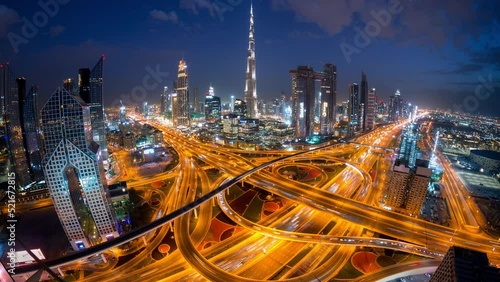 Time lapse of light from car traffic in interchange high rise futuristic concept building in Dubai  at night from top view with wide angle..