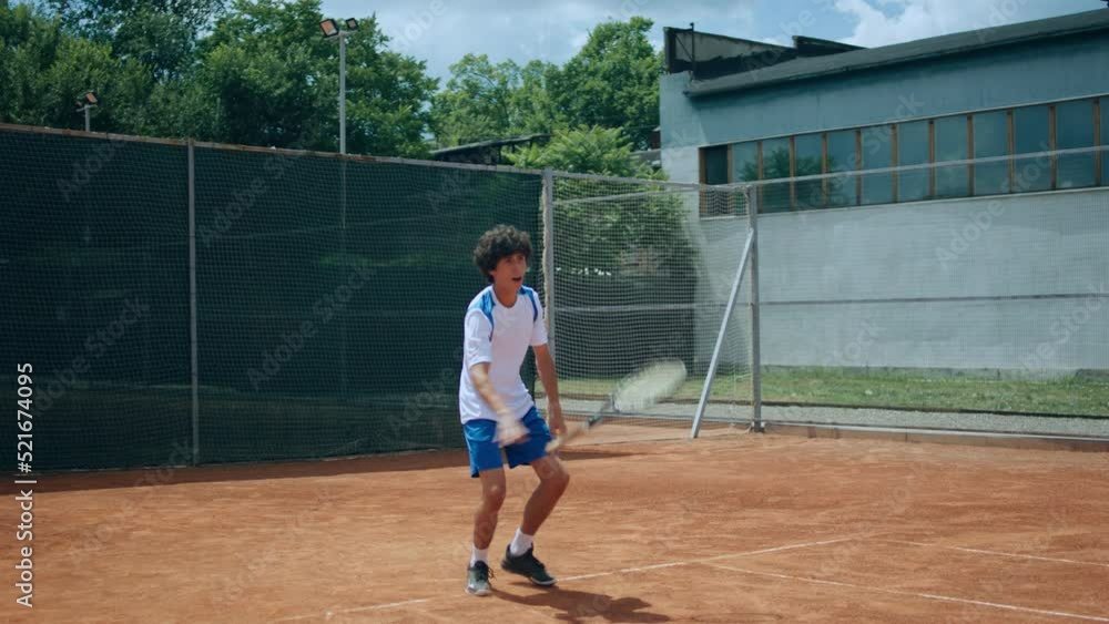 Professional tennis match young guy hitting the ball the sitting on the knees and getting very excited after he win the match outdoor on the clay court Professional tennis match young guy hitting the ball the sitting on the knees and getting very excited after he win the match outdoor on the clay court