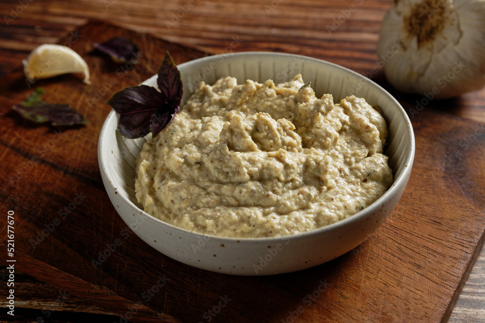 Eggplant cream with feta cheese and garlic. Served in a white bowl. Eggplant cream with feta cheese and garlic. Served in a white bowl.