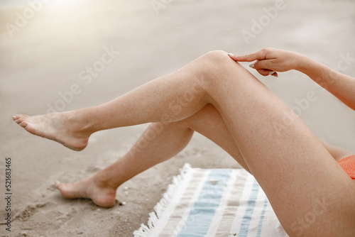 Beautiful women's sexy legs on the beach during vacation. Blurred background