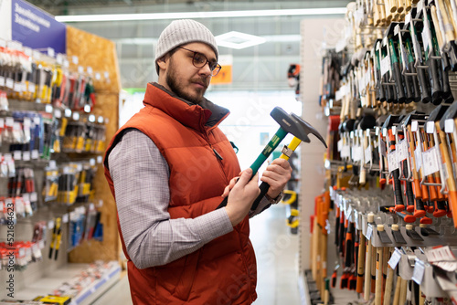 Schilderij op canvas building materials stores a man chooses a new hammer