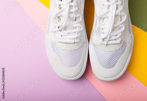 White sneakers on a colored background.Fashion.UNISEX. Sneakers are sports shoes for an active lifestyle. Product photo and levitation concept. Street style. Copy space. Place for text.