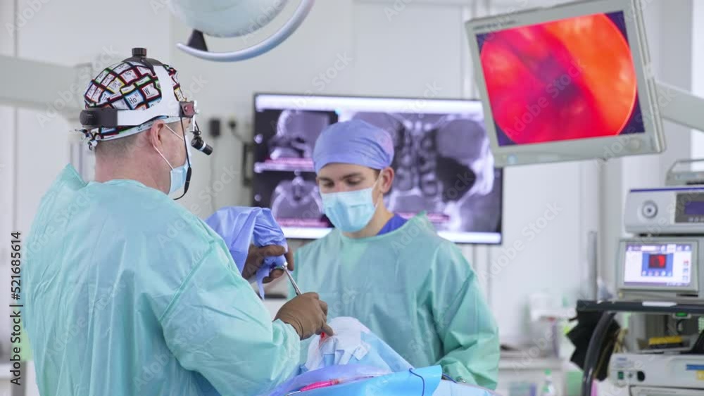 Chief surgeon uses metal tools moving them in the nose of a patient. Doctor watches the screen to see the surgery process. Chief surgeon uses metal tools moving them in the nose of a patient. Doctor watches the screen to see the surgery process.