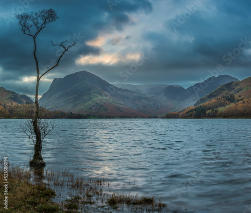 Epic Autumn sunrise landscape image of Buttermere in Lake District with dramatic stormy sky © veneratio