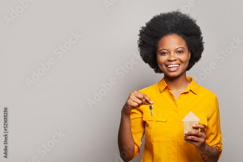 Happy young woman showing her new house keys and smiling at camera