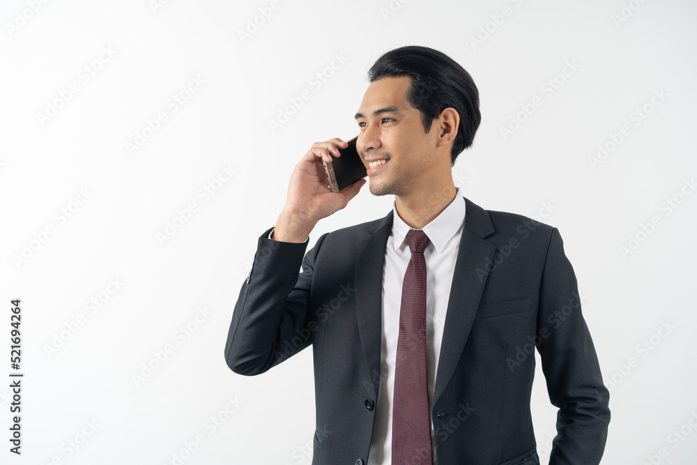 happy young asian businessman smiling and holding a smart phone in formal suit isolated on white background. happy young asian businessman smiling and holding a smart phone in formal suit isolated on white background.