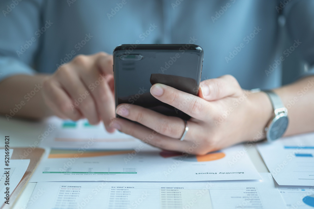 An Asian businesswoman uses a mobile phone to contact a customer to inform her of the company's business partnership. An Asian businesswoman uses a mobile phone to contact a customer to inform her of the company's business partnership.