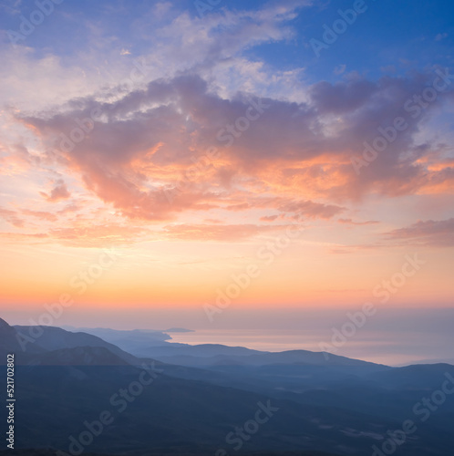 mountain ridge silhouette above sea bay at early morning