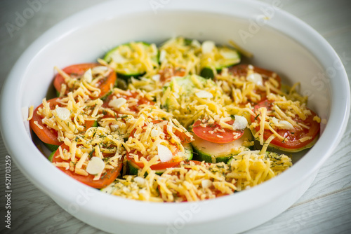 raw zucchini and tomatoes sliced with cheese, prepared for baking