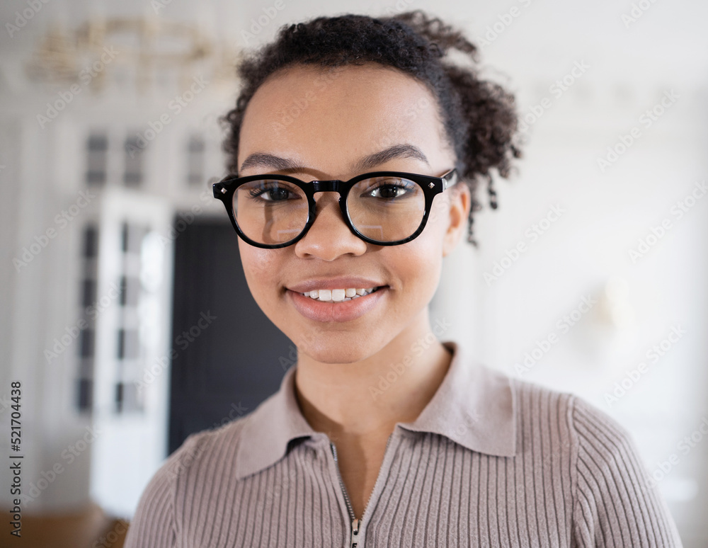 A woman with glasses portrait smiling looking at the camera working in the office A woman with glasses portrait smiling looking at the camera working in the office
