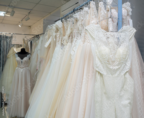 White and cream wedding dresses on a hanger in a bridal boutique