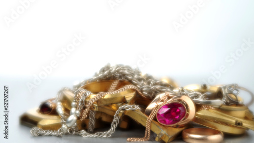 A scrap of precious metals In soft focus. Old and broken gold and silver jewelry, watches of gold and gold-plated lies in a pile. Selective focus.