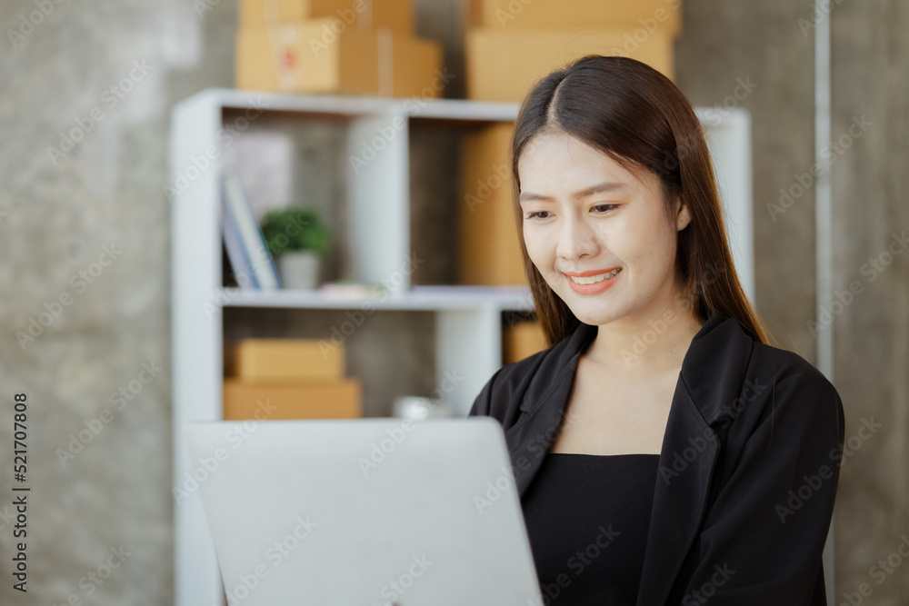 A beautiful Asian business owner opens an online store, she is checking orders from customers, sending goods through a courier company, concept of a woman opening an online business. A beautiful Asian business owner opens an online store, she is checking orders from customers, sending goods through a courier company, concept of a woman opening an online business.
