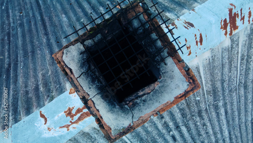 Furnace chimney with traces of soot. Chimney on the roof, covered with old slate. Aerial photography. The camera is down.