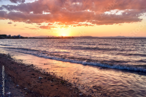 Golden sunset on the beach  over which hung a big cloud