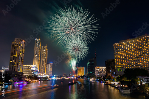 Colorful Firework at river with cityscape night light view of Bangkok skyline at twilight time. New Year celebration fireworks, Thailand Fireworks light up to sky at Christmas and New Year festival © Hathaichanok