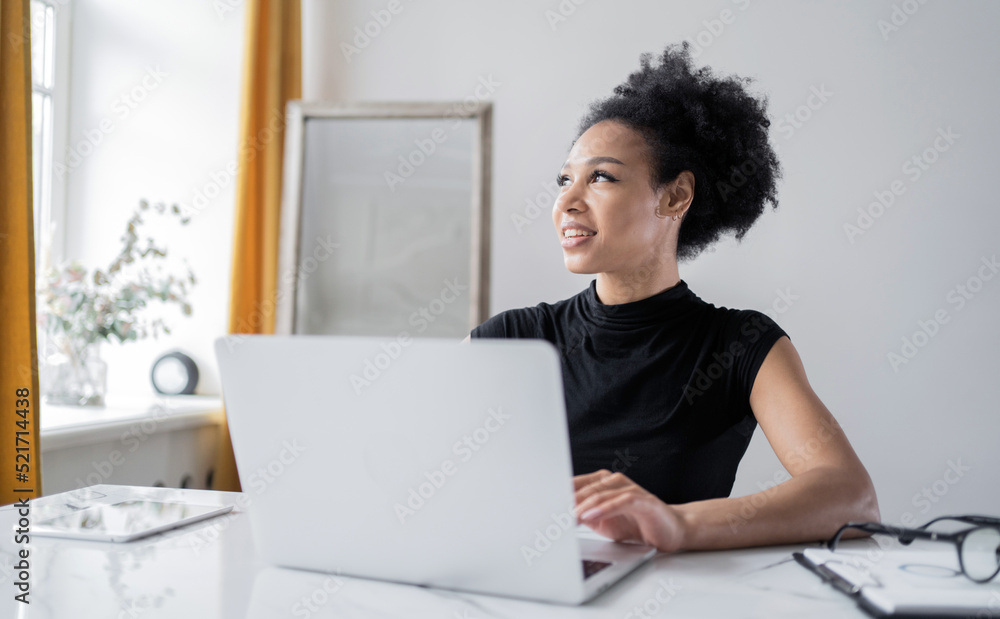 A female employee of a company working online uses a laptop in an office in a coworking space A female employee of a company working online uses a laptop in an office in a coworking space