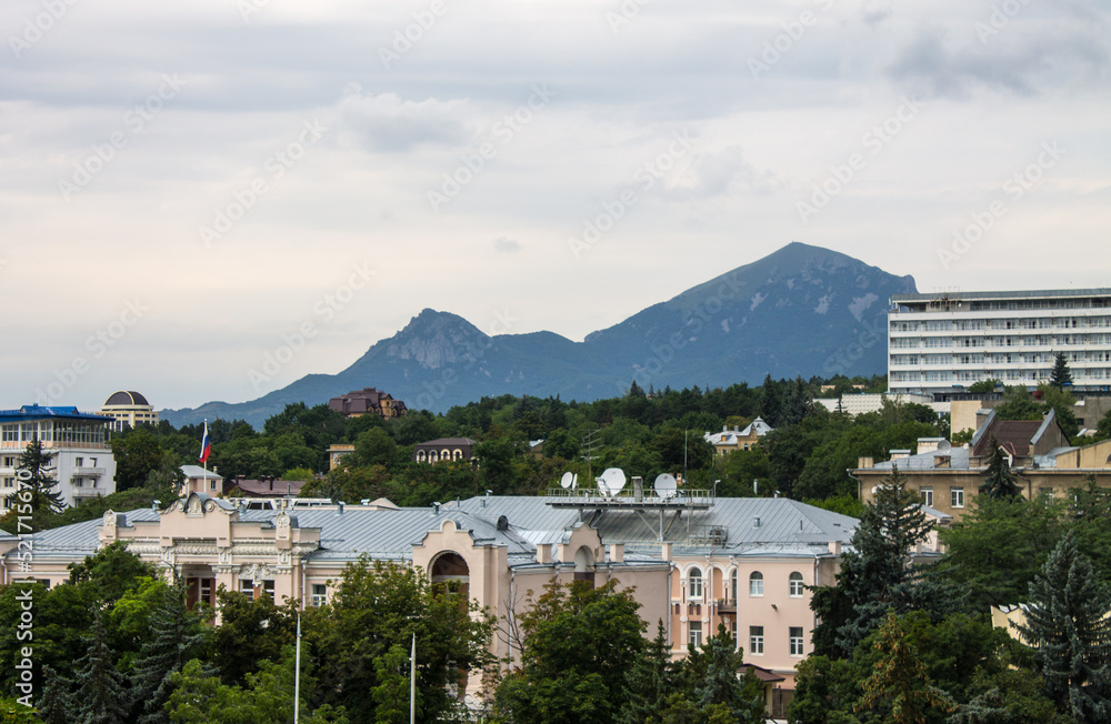 panoramic view of the historic city center with architecture among green trees and Mount Beshtau on the horizon on a cloudy summer day in Pyatigorsk Russia