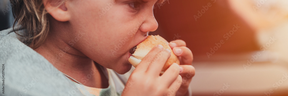 little candid kid boy five year old eats burger or sandwich food sitting in airplane seat on traveling from airport. children take a bite. child in air plane eating lunch or dinner meal. banner. flare little candid kid boy five year old eats burger or sandwich food sitting in airplane seat on traveling from airport. children take a bite. child in air plane eating lunch or dinner meal. banner. flare