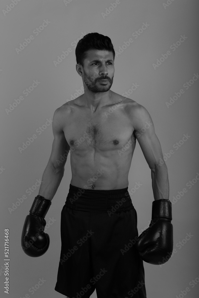 Training of a young strong boxer in black and white