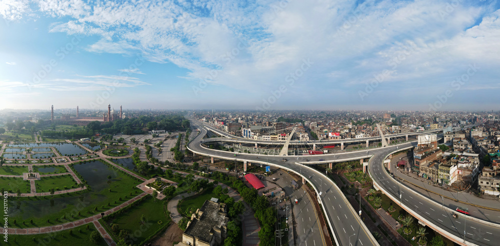 A 180-degree aerial panorama of the old city which includes the Pakistan Monument and its complex, Aazadi Chowk Interchange, and historical Lahore Fort. Captured in the early morning hour. 