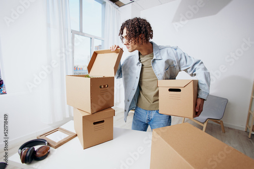 guy with curly hair with boxes moving Lifestyle