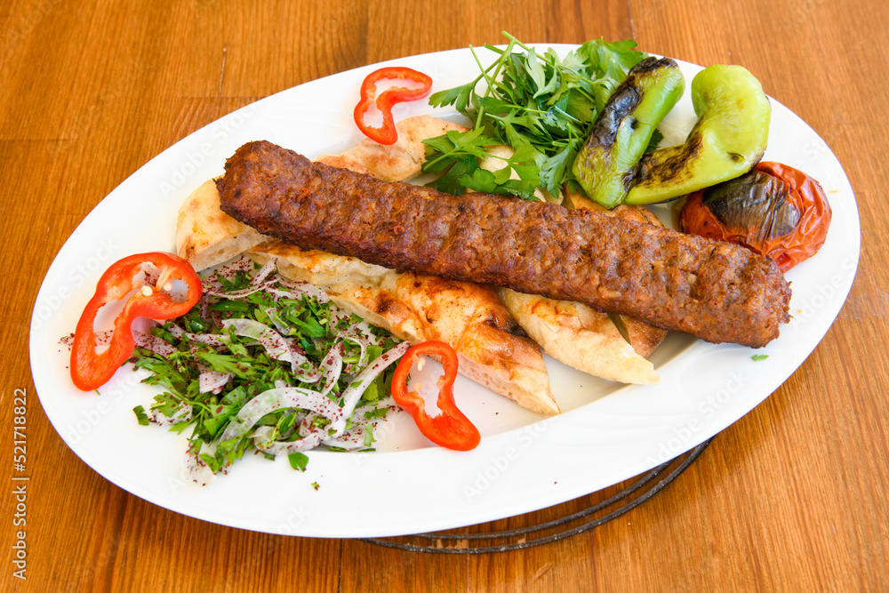 Grilled Turkish Adana, Urfa Kebab with grilled vegetables, onion and rice on plate. Adana durum. Grilled Turkish Adana, Urfa Kebab with grilled vegetables, onion and rice on plate. Adana durum.