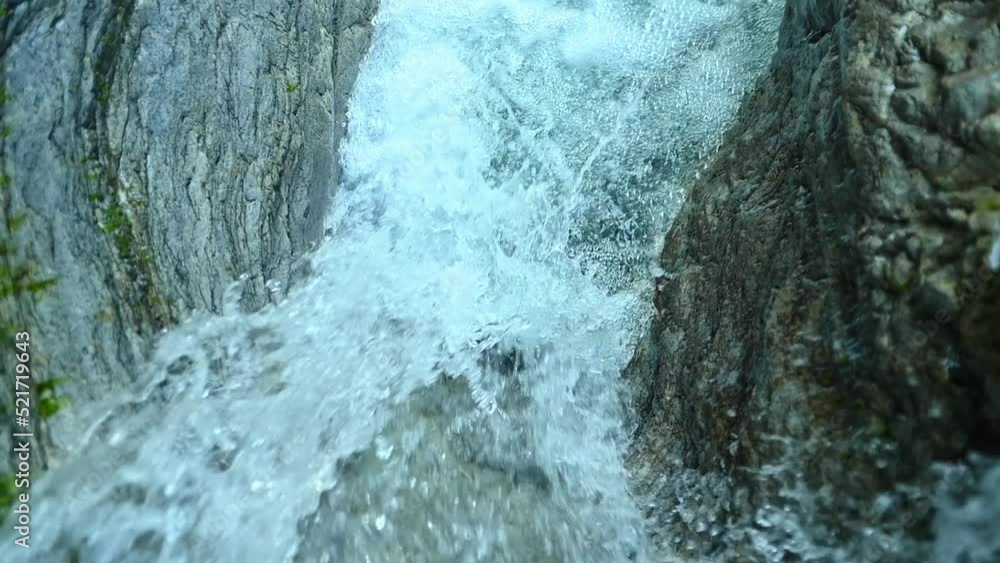 Slow motion of a closeup of a beautiful waterfall between stones of a rivulet in the mountains Slow motion of a closeup of a beautiful waterfall between stones of a rivulet in the mountains