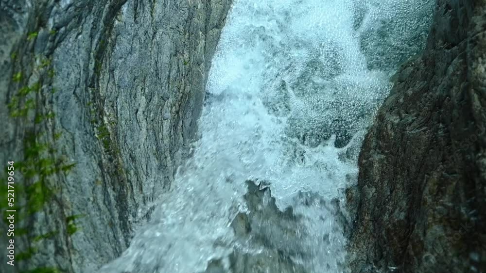 Slow motion of a closeup of a beautiful waterfall between stones of a rivulet in the mountains Slow motion of a closeup of a beautiful waterfall between stones of a rivulet in the mountains