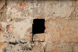 Old red brick wall with a black hole in the middle. The textured background of a vintage brick wall. A panoramic view of an empty wall with copy space can be used for interior design.