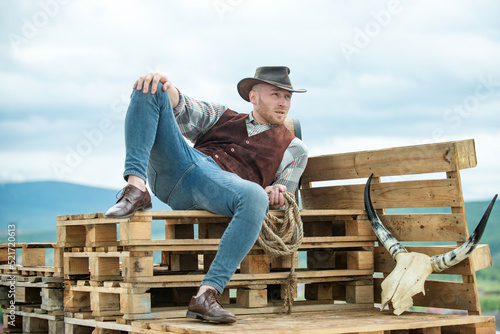 Portrait of farmer or cowboy outdoor. Stylish sexy man looking away.