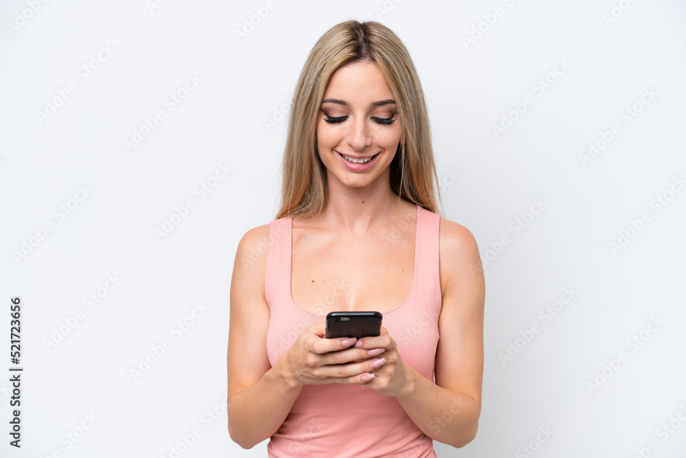 Pretty blonde woman isolated on white background sending a message with the mobile Pretty blonde woman isolated on white background sending a message with the mobile