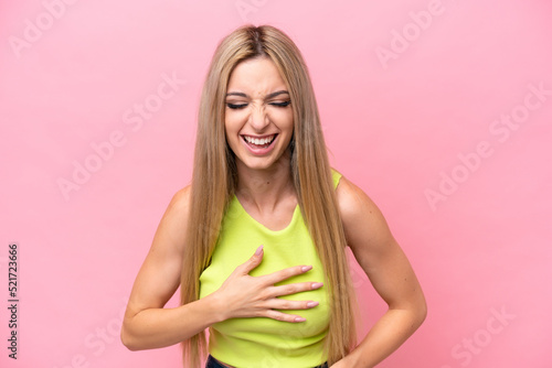 Pretty blonde woman isolated on pink background smiling a lot