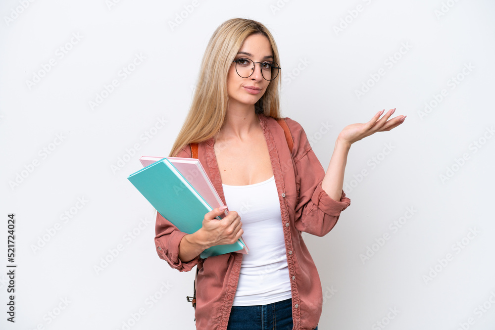 Pretty student blonde woman isolated on white background extending hands to the side for inviting to come Pretty student blonde woman isolated on white background extending hands to the side for inviting to come