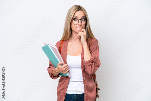 Pretty student blonde woman isolated on white background having doubts and thinking