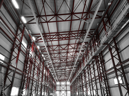 Truss ceiling and metal pillars and girders. Support constructions. Industrial building metal framework. Low angle view