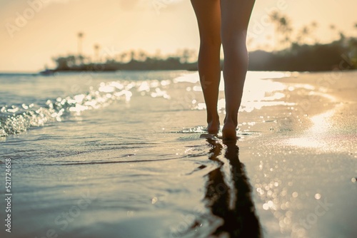 Person walking on the beach shore during sunset. Relaxation in nature paradise.