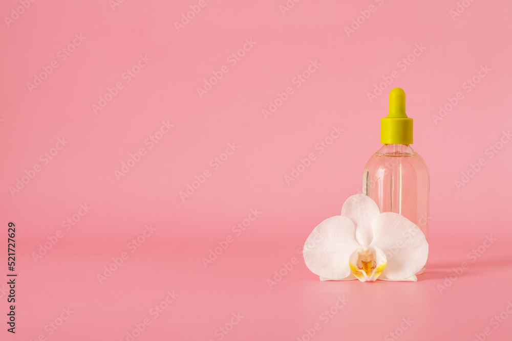 Hyaluronic acid in a glass bottle with pipettewith orchid flower isolated on pink background with clipping path, Liquid gel or serum, skin care cosmetics. Hyaluronic acid in a glass bottle with pipettewith orchid flower isolated on pink background with clipping path, Liquid gel or serum, skin care cosmetics.
