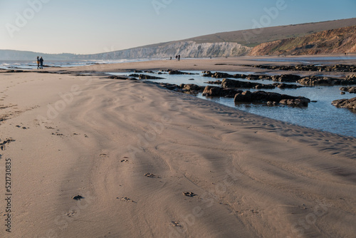sandy beach with rock pools of water