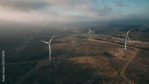 Wind turbines on beautiful sunny summer autumn mountain landsape. Curvy road through mountain Eolic park. Green ecological power energy generation. Wind farm eco field photo