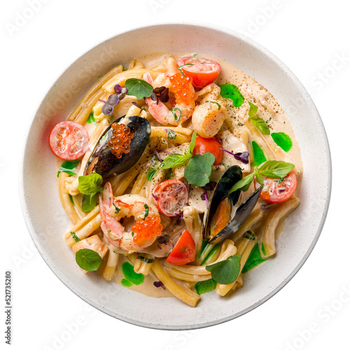 Pasta with seafood, mussels,scallops, shrimps,red caviar and tomatoes on creamy sauce top view isolated on white background