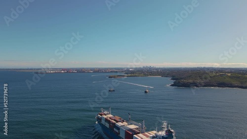 Aerial drone view of a large cargo container ship entering Botany Bay at the coastline of Kurnell and headland of Kamay Botany Bay National Park, Sydney, NSW heading to Port Botany on a sunny day   photo