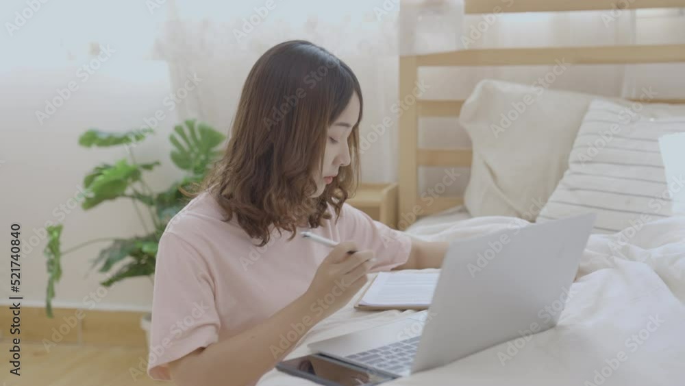 Holiday concept of 4k Resolution. Asian girls working with computers in the bedroom. Holiday concept of 4k Resolution. Asian girls working with computers in the bedroom.