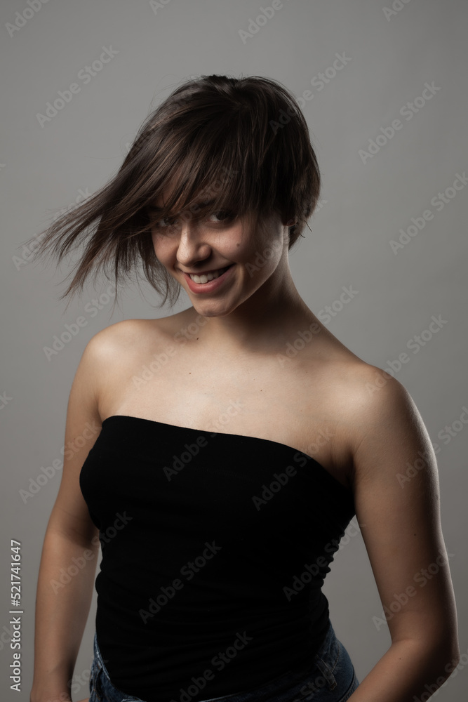 Naklejka premium Beautiful girl upper body portrait. Smiling with wavy hair on face. .