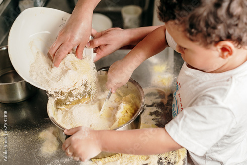 Mom pouring corn flour into a pot for making arepas