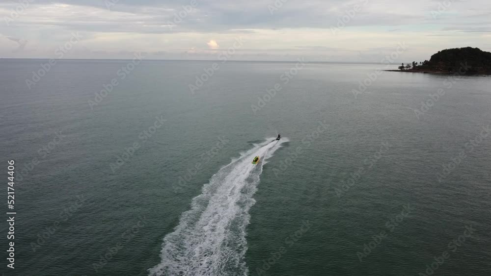 4K video captures the movement of jet skis and banana boats on full speed drive carrying tourists on water activities. 4K video captures the movement of jet skis and banana boats on full speed drive carrying tourists on water activities.